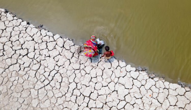 An aerial picture of mother an son by a lake near degraded land